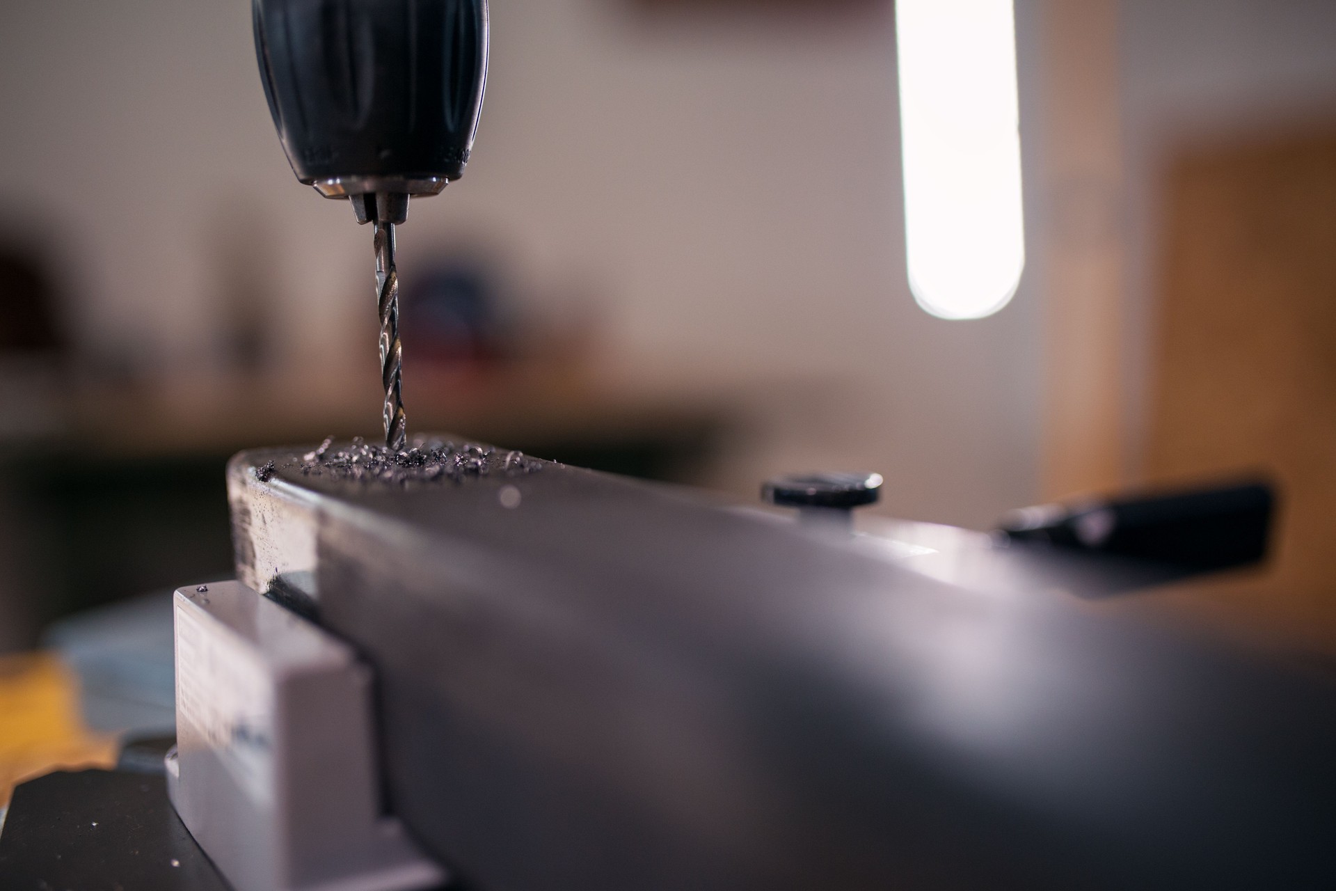 Drilling metal pipe in workshop