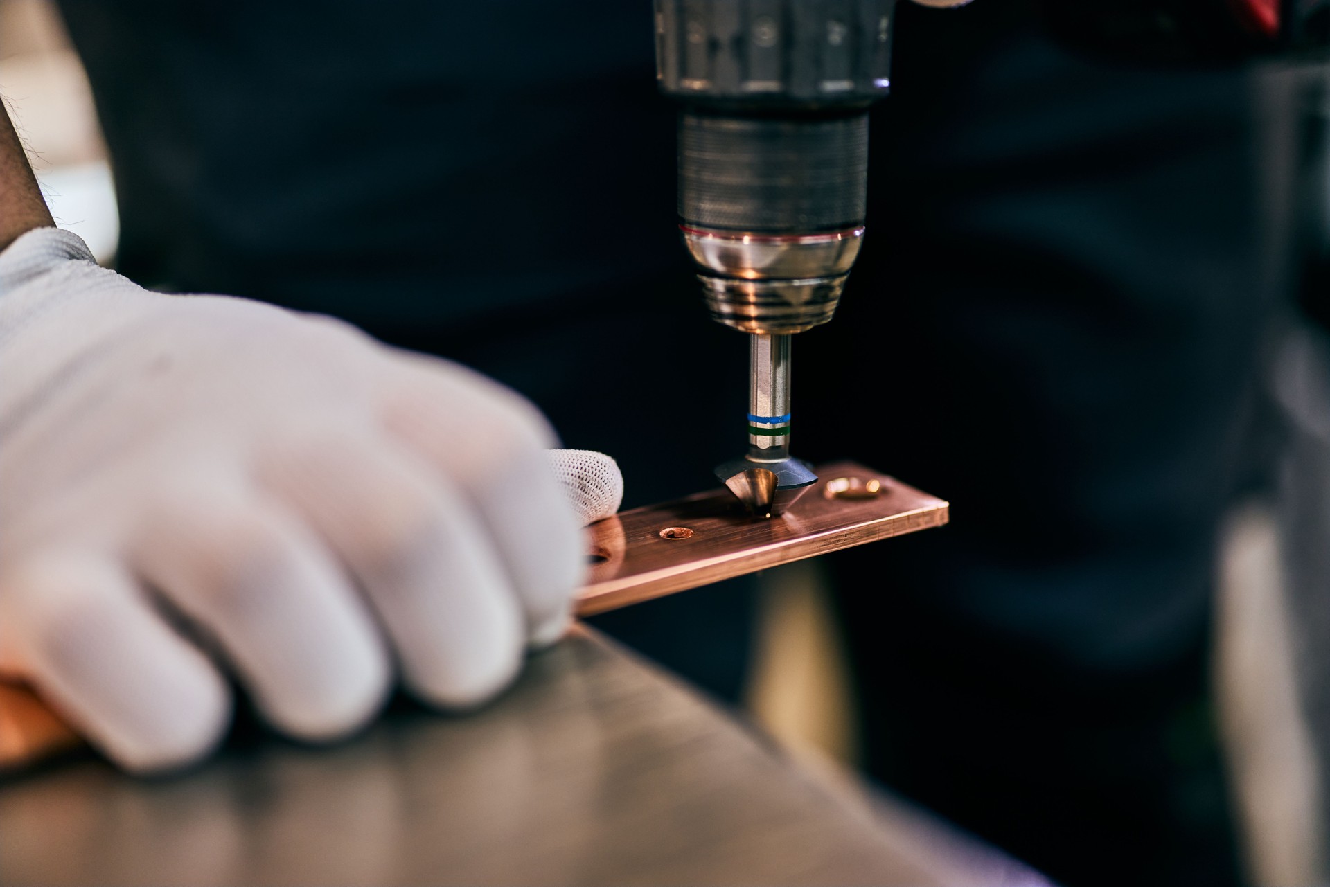 Worker Operating Drill on Metal Component in Workshop Closeup