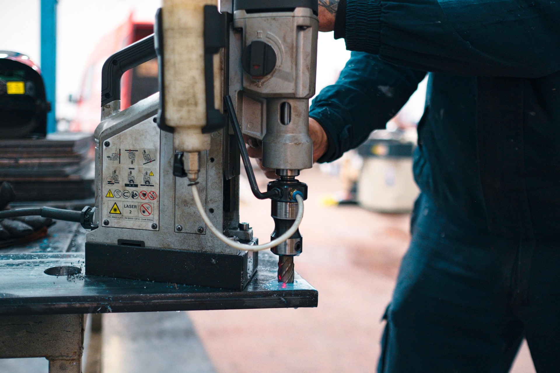 Industrial worker operating magnetic drill press